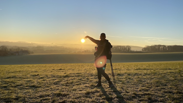 foto van een persoon met een ondergaande zon op de achtergrond